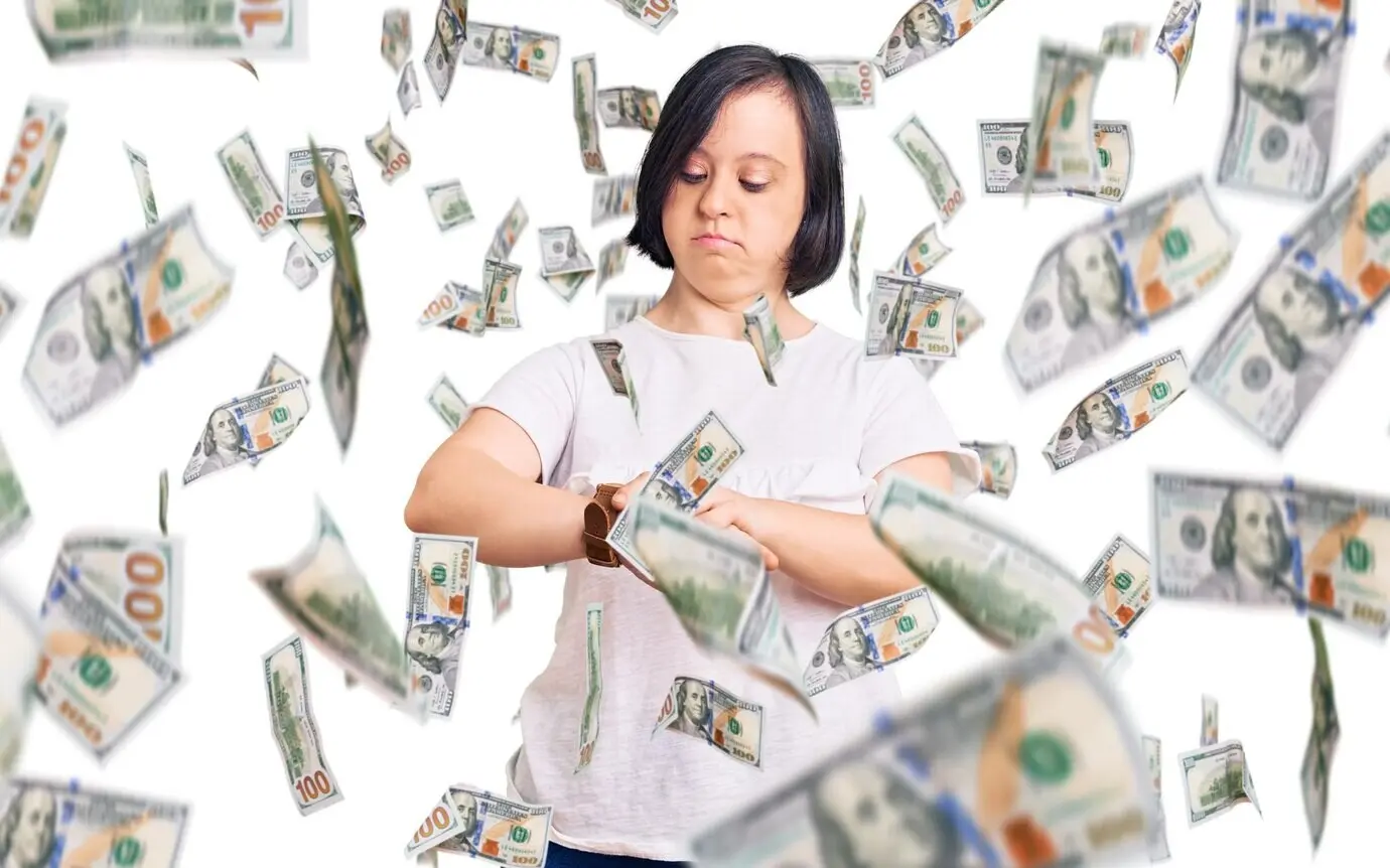 A brunette woman with Down syndrome wearing a casual white T-shirt checks the time on her wristwatch, looking relaxed and confident.